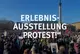 Schriftgrafik: Erlebnisausstellung PROTEST. Dahinter eine Demonstration unter blauem Himmel.